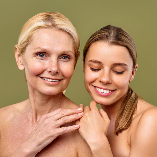 Smiling midlife woman with radiant skin standing beside younger woman, representing collagen support and skin confidence at every age.